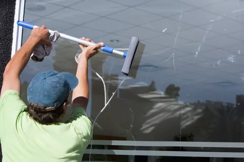 Window cleaner using a squeegee on an exterior pane