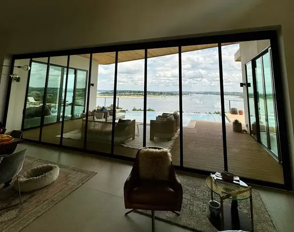 Living room with a wall of clean glass doors looking out over Lake Travis
