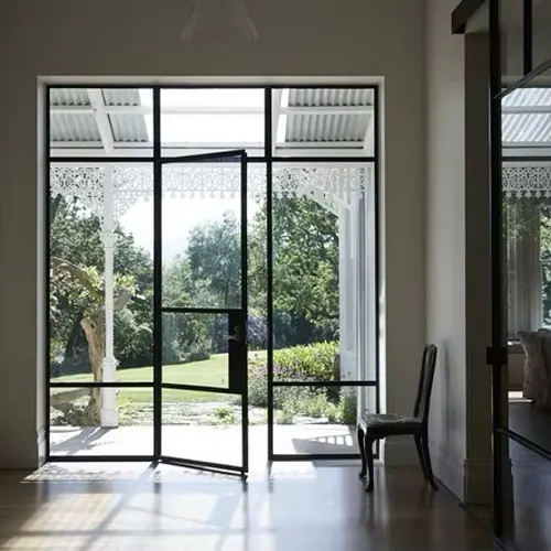 Clean steel-framed glass doors opening onto a garden porch